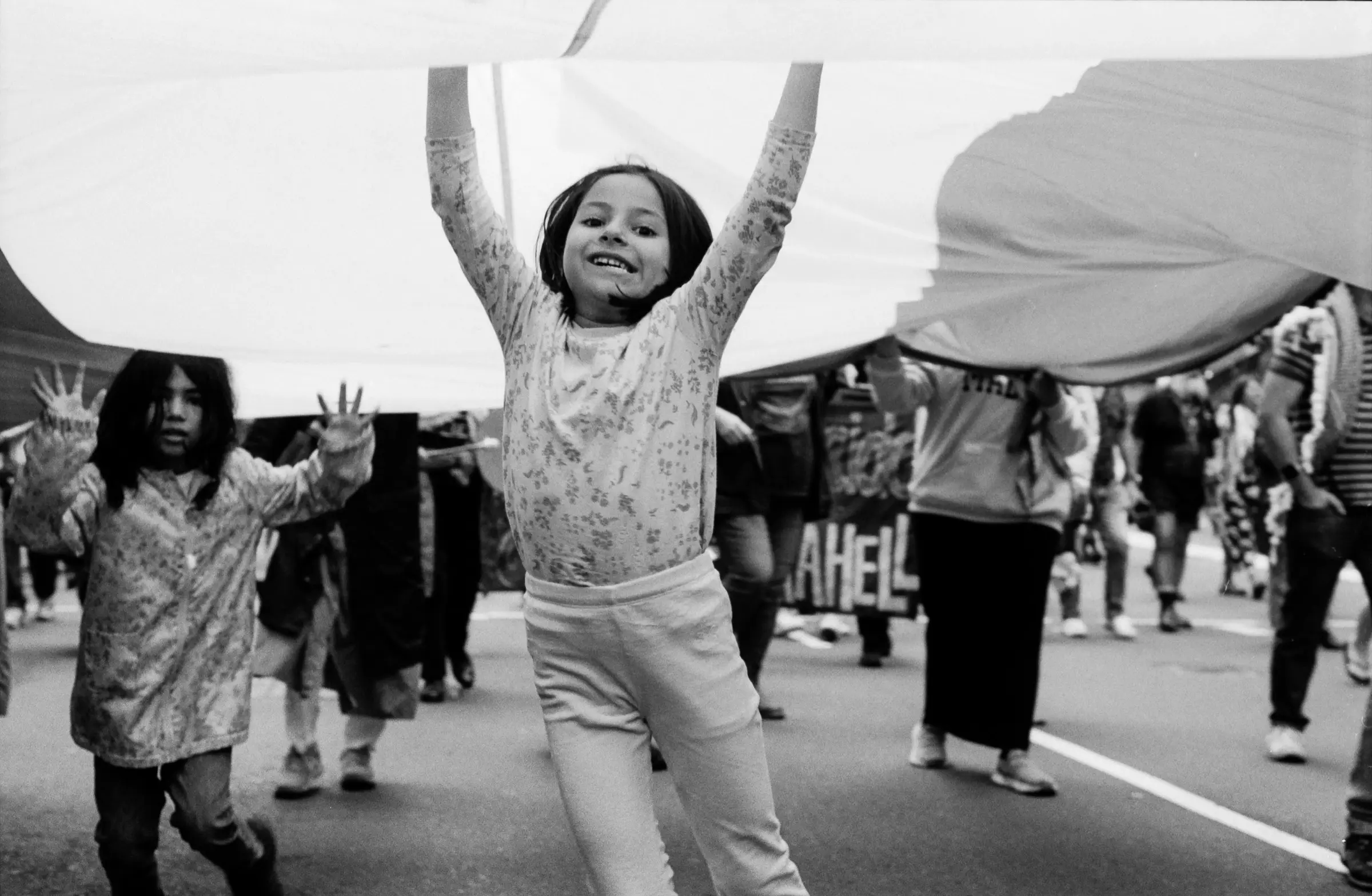 Children beneath a cloth at a street gathering